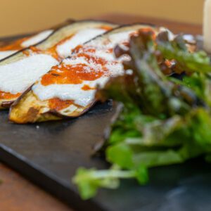 Berinjela ao forno com queijo funtina, molho pomodoro e pesto de manjericão