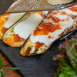 Berinjela ao forno com queijo funtina, molho pomodoro e pesto de manjericão